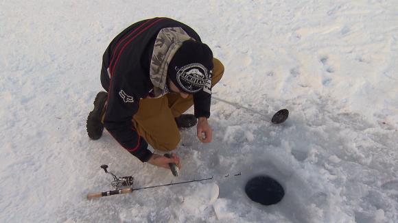 ice fisherman holding fish