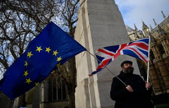 Un hombre con la bandera de la UE y otra del Reino Unido