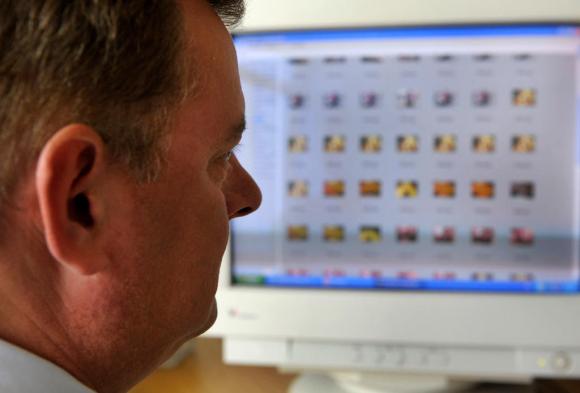 Un policía observa una pantalla de computadora con sitios sospechosos de pornografía