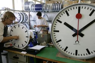 Des ouvriers en train de fabriquer une horloge CFF:
