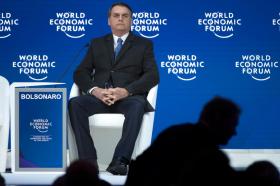 Jair Bolsonaro sentado no palco do WEF