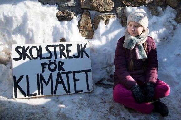 La joven activista sueca Greta Thurnberg sentada en la nieve, en Davos