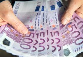 La imagen muestra un par de manos con billetes de 500 euros
