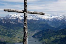 Una cruz de madera en medio de un paisaje rural.