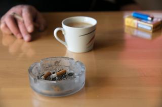 Aschenbecher, Kaffeetasse und Emils Hand am Rauchen