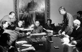 Grupo de militares en torno a una mesa con Pinochet