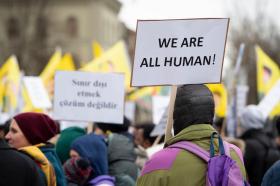 Demonstranten heben Schild mit der Aufschrift We are all human