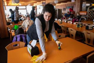 A woman clears the table of a ski resort restaurant