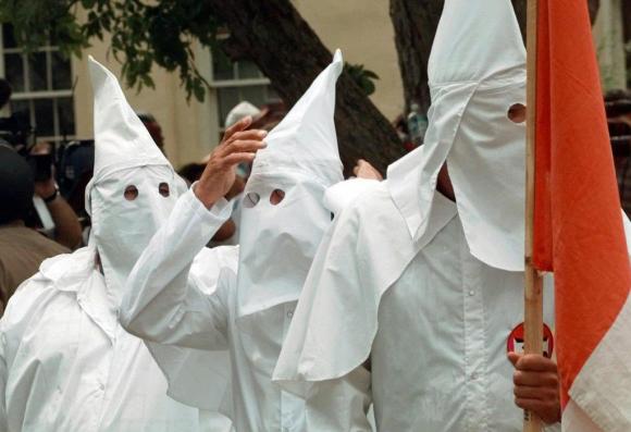 A member of the Ku Klux Klan adjusts his hood