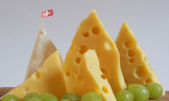 4 pezzi di formaggio Emmentaler e uno di parmigiano disposti in modo che raffigurano vette di montagne.