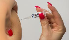 予防接種注射を持つ女性の手