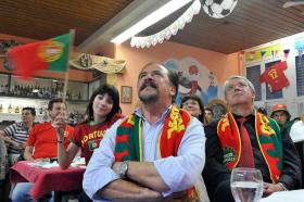 Pessoas assistindo uma partida de futebol na televisão