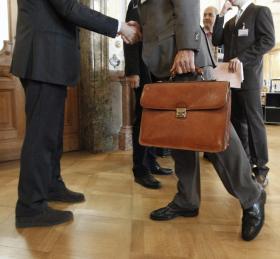 مشهد ترحيب بين رجلين في ردهات البرلمان السويسري في برن