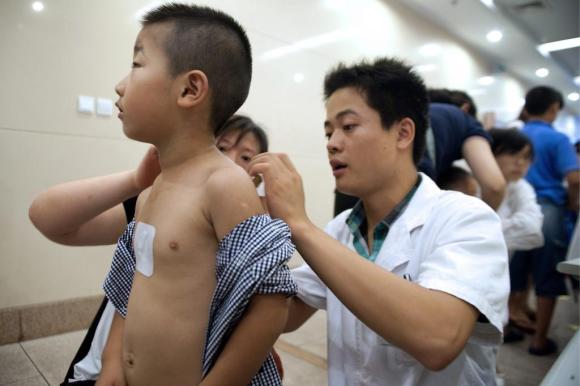 Un médico revisa la espalda de un niño.