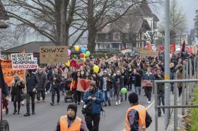 Manifestantes contra el racismo portando globos y pancartas
