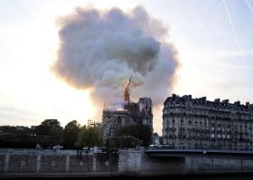 Catedral de Notre Dame vista a la distancia. Se advierten las llamas y una densa nube de humo.