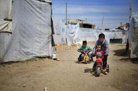 Des enfants jouent au milieu des tentes dans un camp de réfugiés
