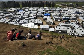 Vista aérea de campo de refugiados y unos niños en una loma