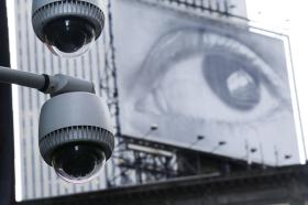 街頭の監視カメラと人の眼が映し出されたスクリーン