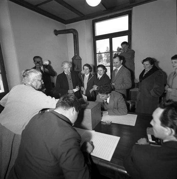 Photo en noir et blanc d un bureau de vote avec des femmes qui votent