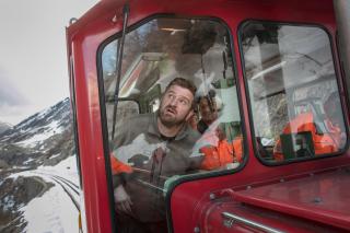 Des hommes dans une locomotive rouge dans la montagne
