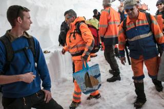 Männer in oranger Arbeitskleidung im Schnee