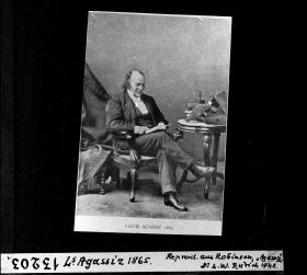 Foto en blanco y negro de un hombre sentado en una silla