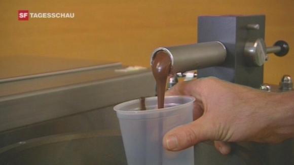 Liquid chocolate flows from a tap into a plastic cup