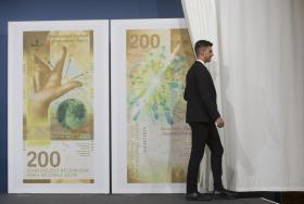 A curtain is drawn open on representations of Swiss francs