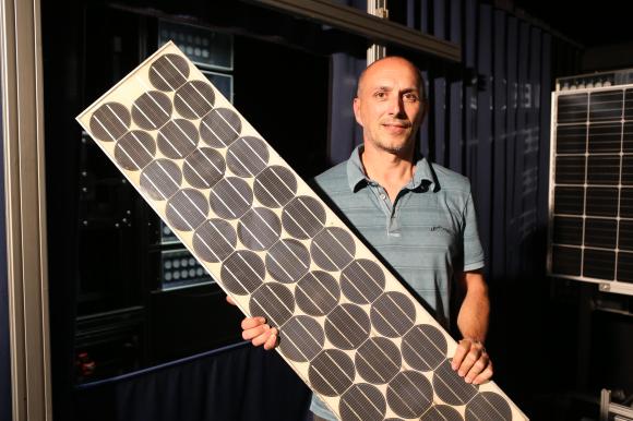 Un homme tient un panneau solaire