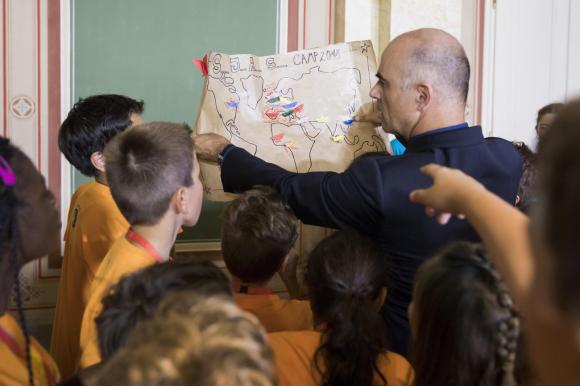 Interior Minister Berset holding a world map drawn by children surrounding him