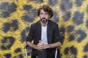 Cineasta gallego Eloy Enciso sentado en el photocall del Festival de Locarno