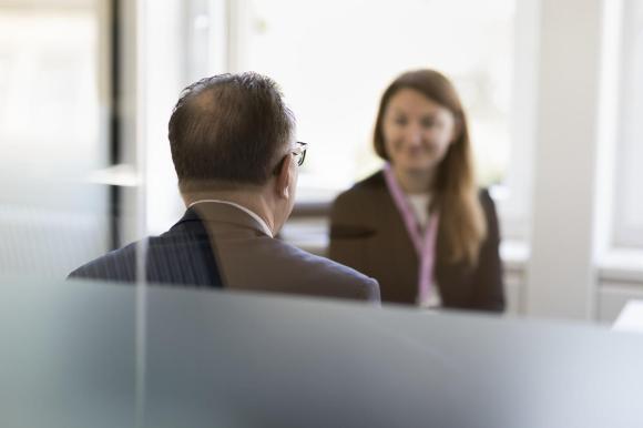 Una mujer habla con un hombre en una oficina