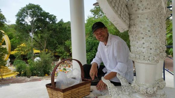 uomo seduto accanto a una statua