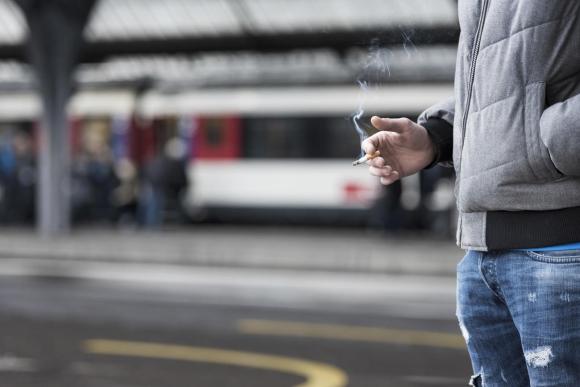 Imagen parcial de un hombre con un cigarrillo.