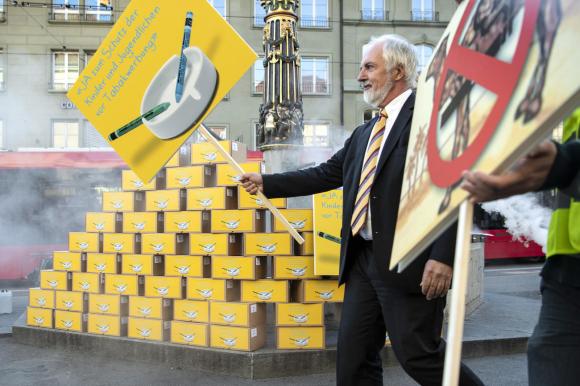 Boxes with initiative signatures, campaigner, banner against tobacco advertising