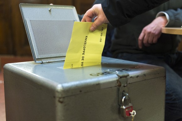 Tre cabine di voto: da una sta uscendo una donna.
