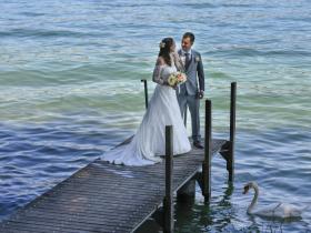 Hochzeitspaar auf Anlegesteg an Seeufer