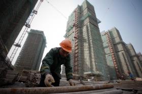 Ein Bauarbeiter, im Hintergrund Hochhäuser.