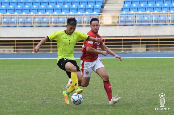 身著台北紅獅隊的球衣：馬費里在中場與對方球員爭搶控球。甲級足球聯賽是台灣最高級別的足球聯賽，但在眾多的體育項目中，足球並非寶島人的摯愛。