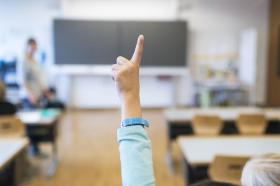 La mano alzada de un alumno en clase