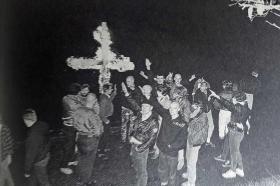 Schweizer Neonazis machen 1989 auf dem Rütli vor einem brennenden Kreuz den Hitlergruss