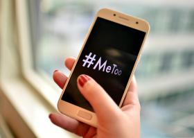 Female hand holding phone with MeToo written on screen