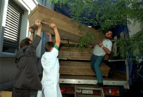Trois hommes portant des cercueils