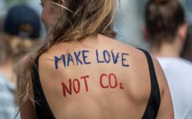 scritta make love not co2 dipinta sulla schiena di una donna