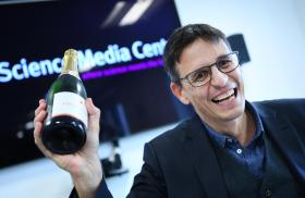Didier Queloz con una botella de champagne
