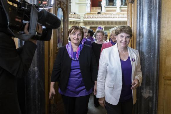 Donne che escono dall aula della Camera del popolo e indossano indumenti color viola, simbolo dello sciopero femminile.