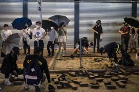 Manifestantes con mascarillas en Hong Kong y miembros de las fuerzas antidisturbios