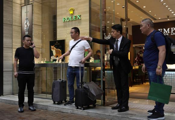 turistas asiáticos saliendo de una tienda de relojes de lujo