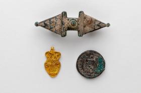 Découvertes archéologiques: une broche, un pendentif en or et une pièce romaine.